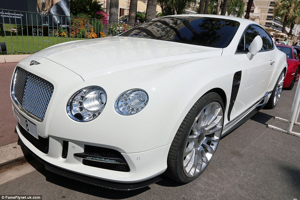 A large white Bentley with tinted windows is parked up on a street in Cannes, France.  A similar influx of cars has been reported in parts of London