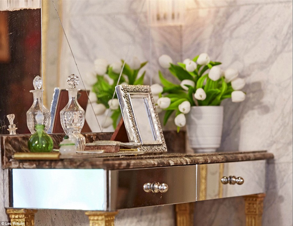 Detailed: Pictured above is an ornate table - complete with pictures frame, a vase of flowers, a brush and a perfume bottle