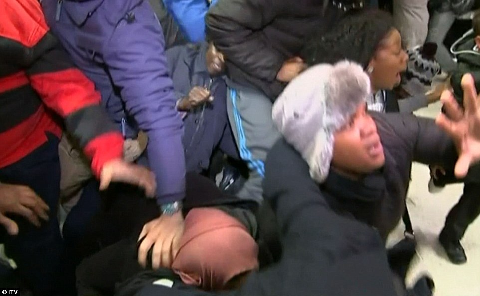 Crushed: A woman is pushed to the ground as another screams while shoppers clamber over each other at Asda in Wembley, north London