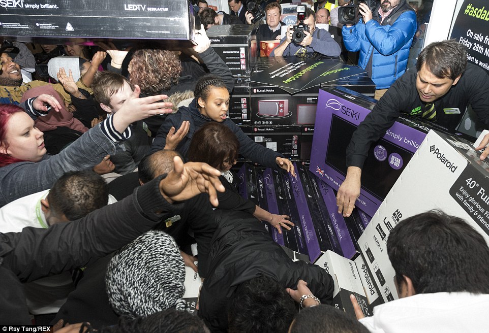 A lone shop assistant hands out Seiki and Polaroid televisions to impatient crowds at Asda in Wembley where hundreds flocked for bargains