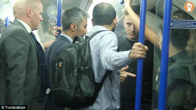 He moves the other commuters out of the way, and firmly tells the man 'groping' the woman to leave her alone