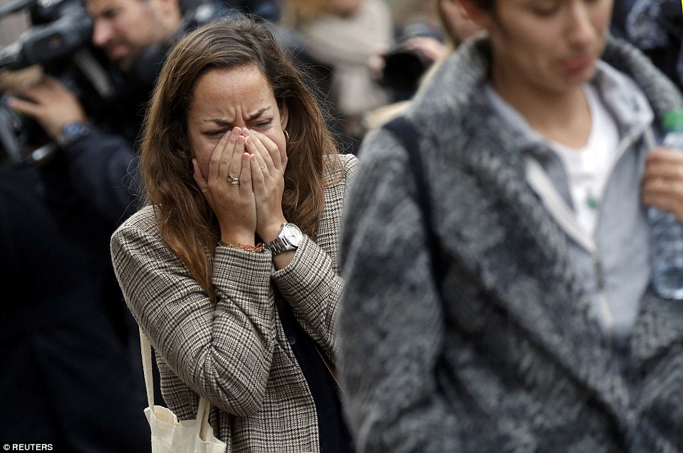 Shock: A woman breaks down in tears while visiting Le Carillon cafe, where around 14 people were killed in the terror attacks
