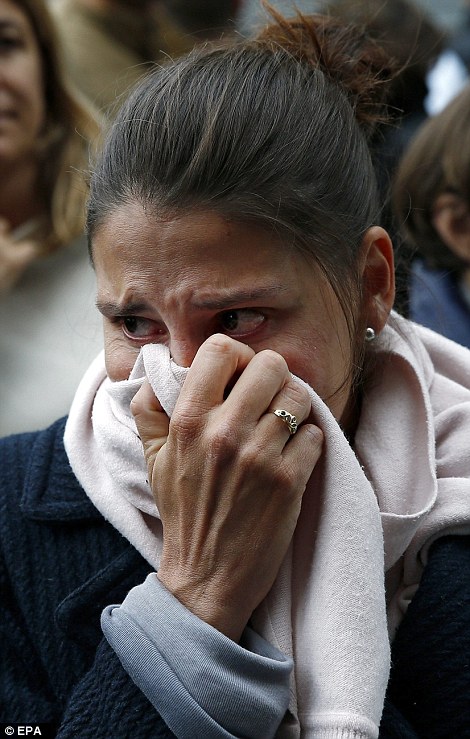A woman cries in front the Carillon cafe in Paris, France