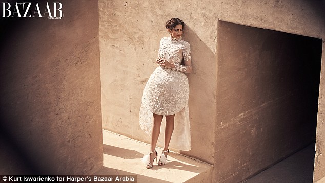 Modelling an off-white tulle dress with a structured skirt embellished with thread work and pearls 